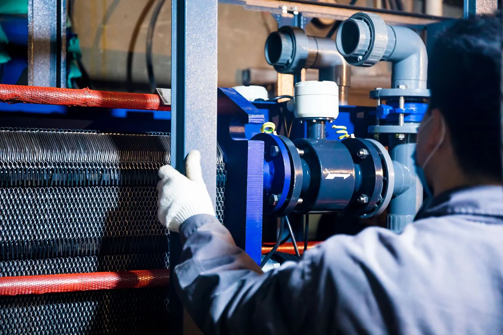 Técnico revisando un intercambiador de calor de placas en planta